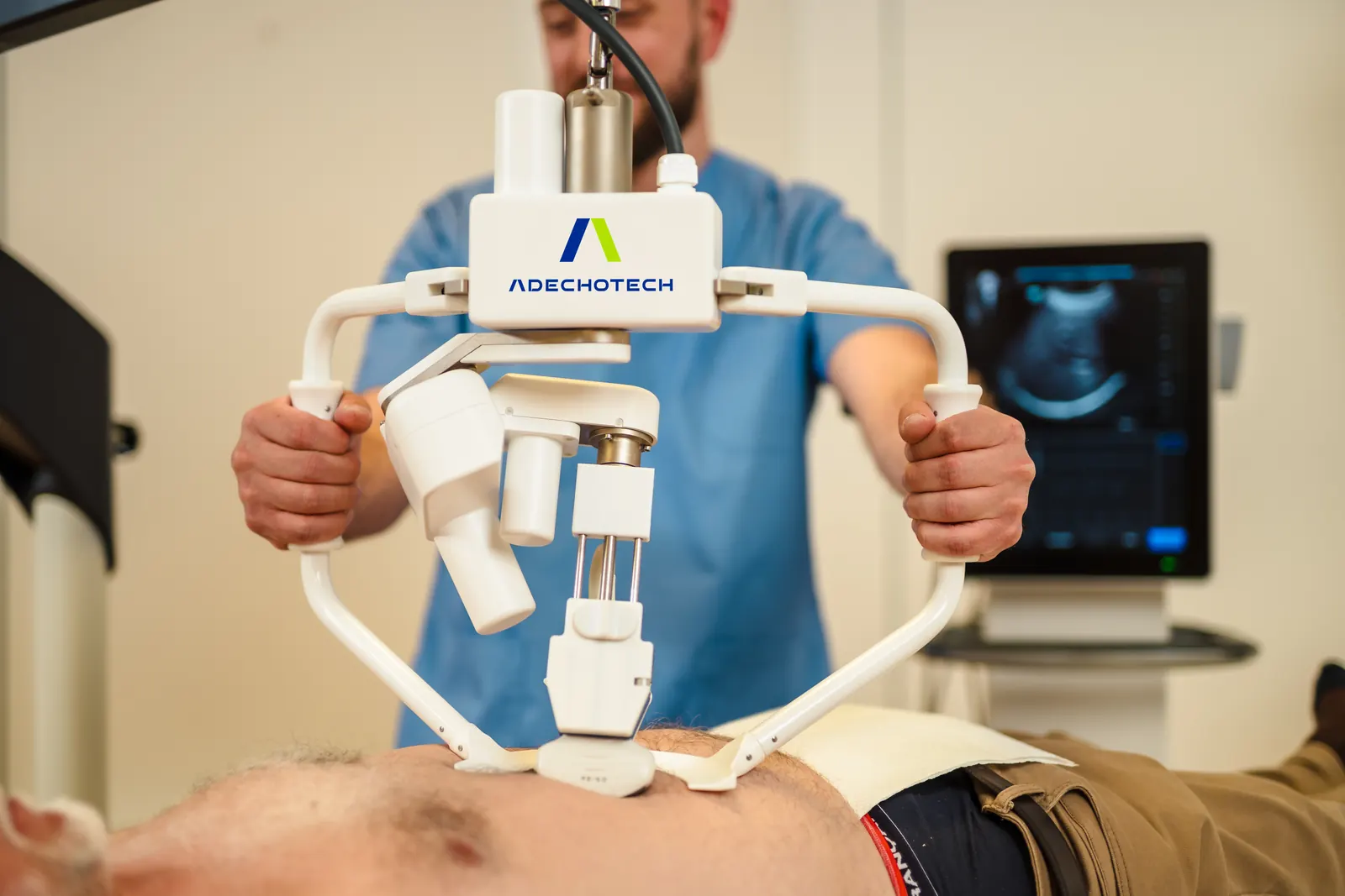 A nurse holds the MELODY robotic arm by its handles during an abdominal examination